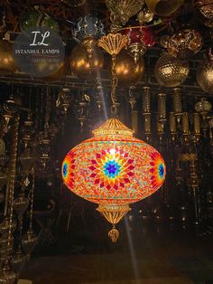 a colorful chandelier hanging from the ceiling in a room filled with other items