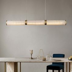 a dining room table with two chairs and a light fixture hanging over it