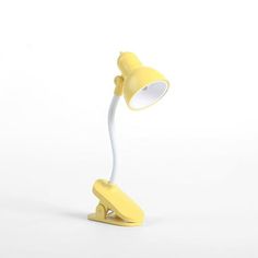 a yellow desk lamp on a white background