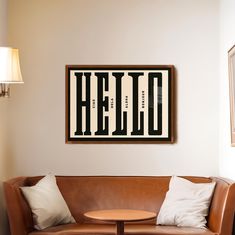 a living room with a couch, table and framed poster on the wall above it