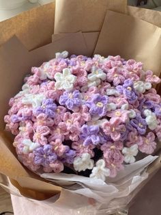 a bouquet of crocheted flowers in a brown paper bag