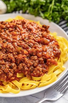 a white plate topped with pasta and meat sauce