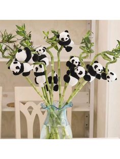 a vase filled with panda bears sitting on top of a table