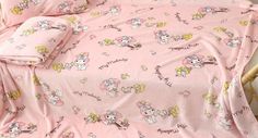 a pink bed with hello kitty sheets and pillows