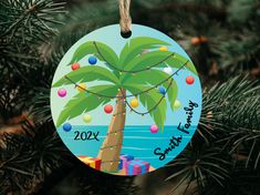 a christmas ornament with a palm tree and beach scene on it's side