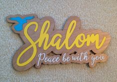 a wooden sign that says shalow peace be with you on the side of a wall