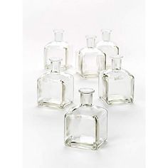 six clear glass bottles sitting next to each other