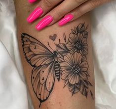 a woman's leg with flowers and a butterfly tattoo on it, while she is wearing pink nail polish