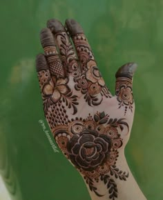 a woman's hand with henna tattoos on it