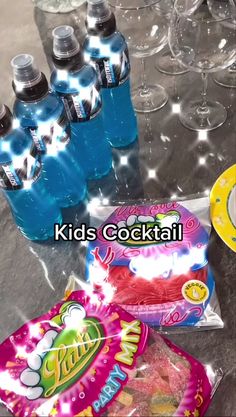 some drinks and snacks on a table with water bottles in the back ground, and two bags of chips next to them