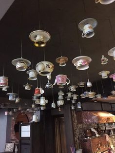 many cups and saucers are hanging from the ceiling