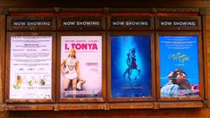 the movie posters are hanging up on the wall in front of the theater's windows