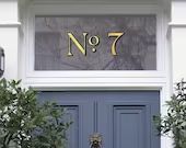 a blue front door with two potted plants on either side and the number seventy