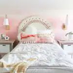 a bedroom with pink walls and white furniture