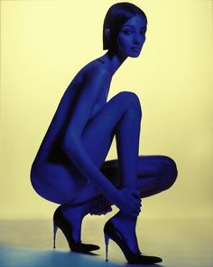 a woman in blue is kneeling down with her legs crossed