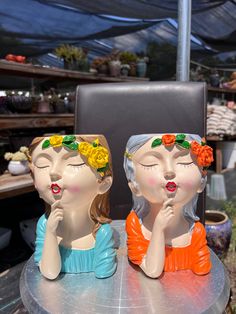 two ceramic figurines sitting on top of a table