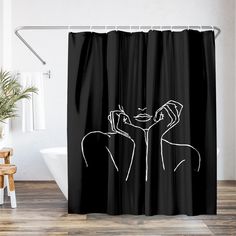 a black and white shower curtain with a woman's face drawn on the side