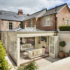 an outdoor living area with white furniture and brick buildings