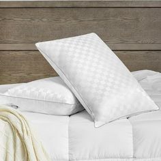 two pillows sitting on top of a white bed