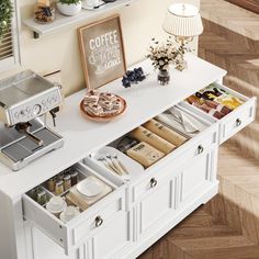 a coffee maker is sitting on top of a white cabinet with drawers and shelves below it