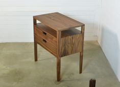 a small wooden table with two drawers on one side and an open drawer on the other