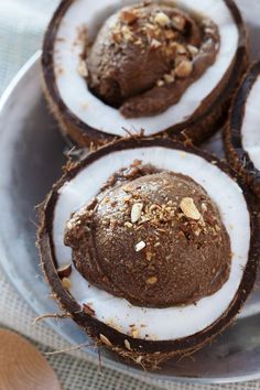 three coconuts with chocolate and nuts in them on a plate