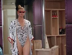 a woman in a zebra print swimsuit walks down the runway