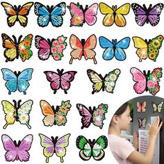 a girl looking at colorful butterflies on the wall with her hand in front of it