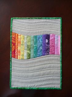 a close up of a piece of cloth on a table with many different colored strips