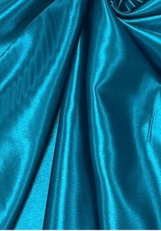 a close up shot of the fabric in teal blue, which is very soft and shiny