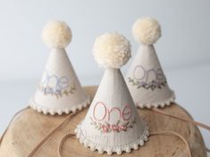 three small white party hats with pom - poms on top of each one