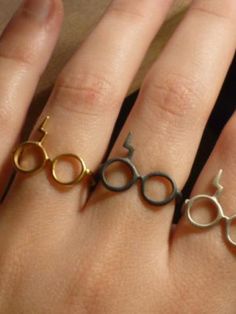 three rings with harry potter symbols on them are sitting on someone's hand,