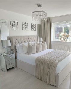 a bedroom with a large bed and chandelier hanging from the ceiling