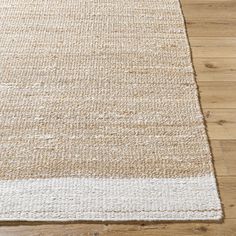 a white rug on top of a wooden floor next to a wood floor with an area rug in the middle