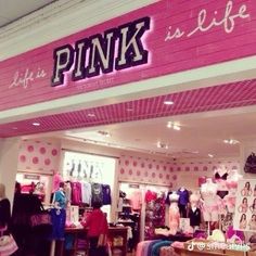 the inside of a pink store with clothes on display and signs that read, life is a pink is life