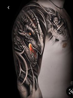 a man's arm with an intricate dragon tattoo on the left side of his body