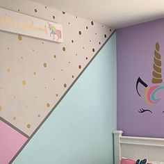 a child's bedroom decorated in pastel colors with a unicorn wall decal