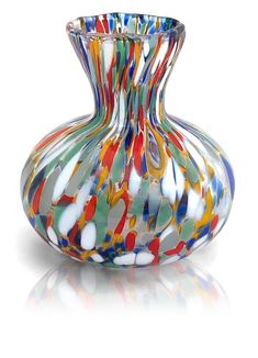 a colorful glass vase sitting on top of a white table