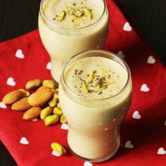 two glasses filled with fruit and nuts on top of a red napkin next to almonds