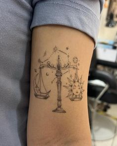 a lady with a tattoo on her arm that has an image of the scales of justice