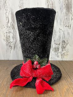 a black top hat with a red bow