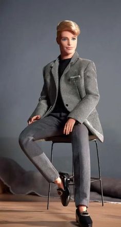 a man sitting on top of a chair wearing a suit