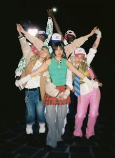 a group of young people standing next to each other with their arms in the air