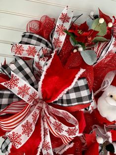 a red and white christmas wreath with a teddy bear