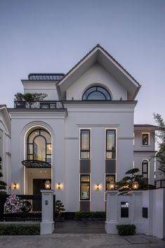 a large white house with lots of windows on it's front door and balcony