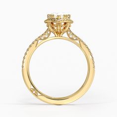 a yellow gold engagement ring with an oval cut diamond on the center and side stones