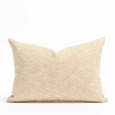 a beige pillow on a white surface with a black and white pattern in the middle