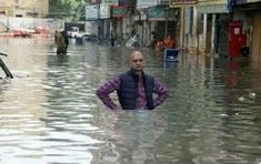 a man standing in the middle of a flooded street