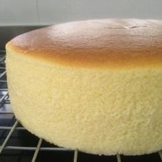 a round cake sitting on top of a metal rack in front of an oven door