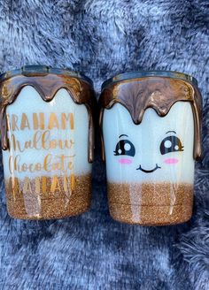 two coffee mugs that have been decorated with chocolate and marshmallows on them